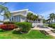 Landscaped exterior featuring well-maintained lawn, mature trees, water views, and a private spa, creating a picturesque home at 17382 Kennedy Dr, North Redington Beach, FL 33708