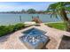 Outdoor spa with tiled fountain and private dock, overlooking the wide canal and providing a serene waterfront experience at 17382 Kennedy Dr, North Redington Beach, FL 33708