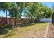 A backyard with a grassy lawn, mature trees, and a brick-lined border, offering a private outdoor space at 1751 Split Fork Dr, Oldsmar, FL 34677