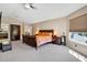 Bedroom with a ceiling fan, neutral walls, carpet flooring, and two large windows at 1751 Split Fork Dr, Oldsmar, FL 34677