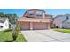 Two-story home featuring a three-car garage and wide driveway at 1751 Split Fork Dr, Oldsmar, FL 34677