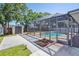 Screened pool and storage shed in a fenced backyard with grass at 1751 Split Fork Dr, Oldsmar, FL 34677