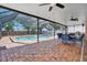 Relaxing screened-in pool area with brick pavers, ceiling fans, and outdoor kitchen at 1751 Split Fork Dr, Oldsmar, FL 34677
