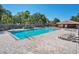A community pool with lounge chairs, umbrellas, and clear blue water, all set on a brick patio on a sunny day at 1751 Split Fork Dr, Oldsmar, FL 34677