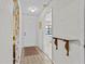 View of foyer with ceramic tiles, coat closet, and half-wall decorated with floral wallpaper at 1800 Mariner Dr # 2, Tarpon Springs, FL 34689