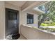 A close-up featuring the condo's front door with adjacent window and textured wall finish at 1800 Mariner Dr # 2, Tarpon Springs, FL 34689