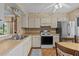 Kitchen features white appliances, white cabinets, and an eat-in kitchen area with wooden floors at 1800 Mariner Dr # 2, Tarpon Springs, FL 34689