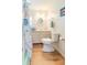 Well-lit bathroom with seashell shower curtain, oval mirror, and tile flooring at 18675 Us Highway 19 N # 140, Clearwater, FL 33764
