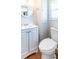 Clean, bright bathroom featuring a white vanity and toilet, wood floors, and ample storage at 18675 Us Highway 19 N # 140, Clearwater, FL 33764