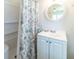 Clean, bright bathroom featuring a white vanity, toilet, shower and round mirror at 18675 Us Highway 19 N # 140, Clearwater, FL 33764