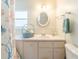 Bathroom featuring seashell themed shower curtain and white cabinets at 18675 Us Highway 19 N # 140, Clearwater, FL 33764