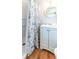 Clean, bright bathroom featuring a white vanity, toilet, shower and round mirror at 18675 Us Highway 19 N # 140, Clearwater, FL 33764