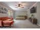 Bright bedroom featuring a ceiling fan, TV, and a cozy orange sofa with ottoman at 1916 River Crossing Dr, Valrico, FL 33596