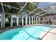 Screened-in pool area featuring a refreshing pool, lounge chairs, and shaded relaxation space at 1916 River Crossing Dr, Valrico, FL 33596