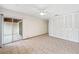 This bedroom has tile floors, a ceiling fan, large closet, and access to an outdoor patio through sliding glass doors at 2070 Sunset Point Rd # 111, Clearwater, FL 33765
