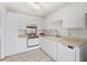 Clean and bright kitchen featuring white cabinetry and appliances with tile flooring, great for functionality at 2070 Sunset Point Rd # 111, Clearwater, FL 33765