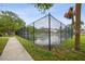 Outdoor tennis court surrounded by a tall fence and greenery, offering recreational opportunities for residents at 2070 Sunset Point Rd # 111, Clearwater, FL 33765