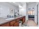 Bright bathroom showcasing a double vanity, large mirror and view of primary bedroom at 2150 River Turia Cir, Riverview, FL 33578