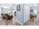 Light-filled living room featuring wood-look flooring, ceiling fan, and doorway to bedroom at 2150 River Turia Cir, Riverview, FL 33578