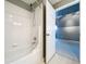 Bright bathroom featuring a white tiled shower and a view into the bonus room at 24314 Landing Dr, Lutz, FL 33559