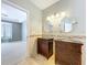 Bright bathroom featuring double vanity with granite counters, round mirrors and a window view of the adjacent room at 24314 Landing Dr, Lutz, FL 33559
