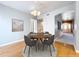 The dining room features a round wood table with four gray upholstered chairs and a modern chandelier above at 24314 Landing Dr, Lutz, FL 33559