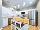 Bright kitchen features stainless appliances, white cabinetry, hardwood floors and a central island with seating at 24314 Landing Dr, Lutz, FL 33559