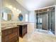 Elegant main bathroom with dual vanities, tile flooring, and large glass shower with wood ceiling at 24314 Landing Dr, Lutz, FL 33559