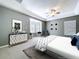 The main bedroom boasts a tray ceiling, a bay window seat, a modern dresser, and neutral decor at 24314 Landing Dr, Lutz, FL 33559