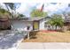 Charming home with a yellow door, an American flag, mature landscaping and a well-manicured lawn at 2604 Shilo Ct, Valrico, FL 33596