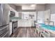 Bright kitchen boasts stainless steel appliances, white cabinets, a mosaic tile backsplash and new floors at 2604 Shilo Ct, Valrico, FL 33596