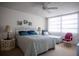 Bright bedroom with a ceiling fan, a large window, and a queen bed with a blue striped bedspread at 2630 Pearce Dr # 104, Clearwater, FL 33764