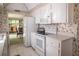 Bright kitchen features white cabinets, appliances, and unique strawberry wallpaper at 2630 Pearce Dr # 104, Clearwater, FL 33764