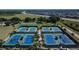 Aerial view of tennis courts surrounded by palm trees, next to residential area at 29909 Baywood Ln, Wesley Chapel, FL 33543