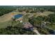 Stunning aerial view showcasing the home's location on a lush golf course with mature trees and a tranquil lake at 29909 Baywood Ln, Wesley Chapel, FL 33543