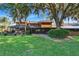 Large backyard with screened in patio, green lawns, mature trees and landscaping at 29909 Baywood Ln, Wesley Chapel, FL 33543