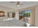 Bedroom featuring a ceiling fan, sliding glass doors to balcony, and mirrored closet doors at 29909 Baywood Ln, Wesley Chapel, FL 33543