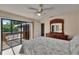 Bright bedroom with sliding doors leading to the balcony, beautiful dresser and light gray wood floor at 29909 Baywood Ln, Wesley Chapel, FL 33543