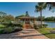 Charming community center with brick walkway, lush landscaping, and scenic views of the adjacent lake at 29909 Baywood Ln, Wesley Chapel, FL 33543