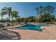 Inviting community pool area featuring brick pavers, comfortable lounge chairs, and picturesque lake views at 29909 Baywood Ln, Wesley Chapel, FL 33543
