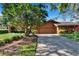 Long driveway leading up to the exterior of the home with lush greenery, palm trees, and stone accents at 29909 Baywood Ln, Wesley Chapel, FL 33543