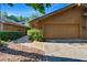 Home exterior with a two-car garage, manicured bushes, and a stone walkway surrounded by grass and foliage at 29909 Baywood Ln, Wesley Chapel, FL 33543