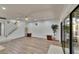 Bright living room with wood flooring, ceiling fan, staircase, and sliding glass doors to the patio at 29909 Baywood Ln, Wesley Chapel, FL 33543