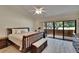 Spacious main bedroom featuring a sliding door to a private balcony with serene nature views at 29909 Baywood Ln, Wesley Chapel, FL 33543