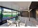 Enclosed patio with brick floor, glass table and chairs overlooking green lawns at 29909 Baywood Ln, Wesley Chapel, FL 33543