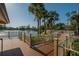 Scenic pool deck with palm trees, manicured landscaping, and views of the sparkling lake at 29909 Baywood Ln, Wesley Chapel, FL 33543