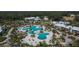 Aerial view of a large outdoor pool area surrounded by palm trees and buildings in a community at 29909 Baywood Ln, Wesley Chapel, FL 33543