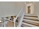 Upstairs staircase featuring view of bathroom and living room at 29909 Baywood Ln, Wesley Chapel, FL 33543