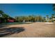 Outdoor tennis court with a paved surface, surrounded by lush trees and featuring a fountain at 29909 Baywood Ln, Wesley Chapel, FL 33543