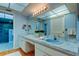 Bright bathroom featuring a marble countertop, white cabinets and a connecting walk-in shower at 3310 Tanglewood Trl, Palm Harbor, FL 34685